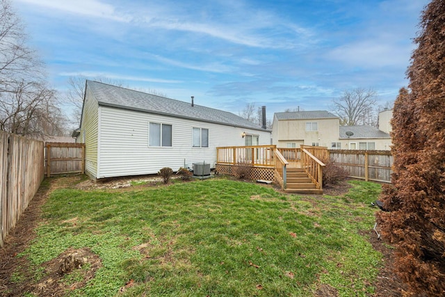 rear view of property with a yard, central AC, and a deck