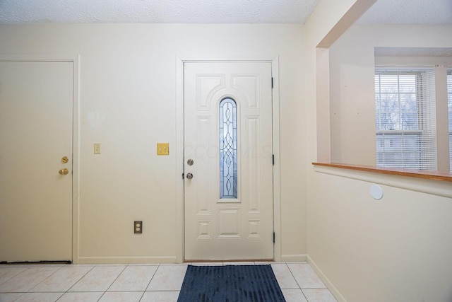 tiled entryway featuring a textured ceiling