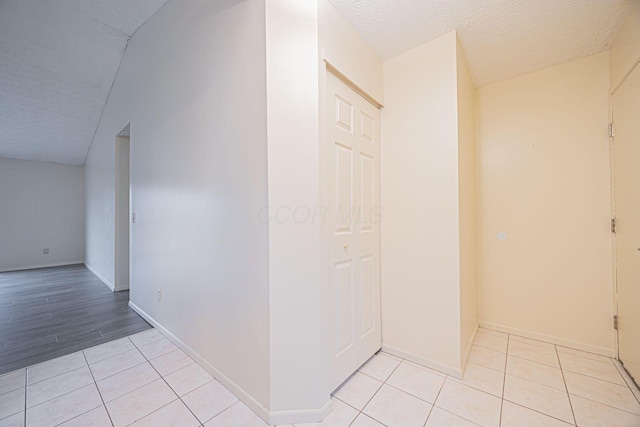 hallway with light tile patterned flooring and a textured ceiling