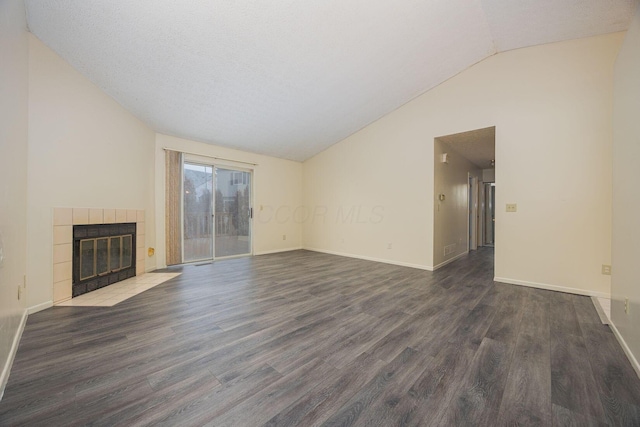 unfurnished living room with dark hardwood / wood-style floors, lofted ceiling, and a fireplace