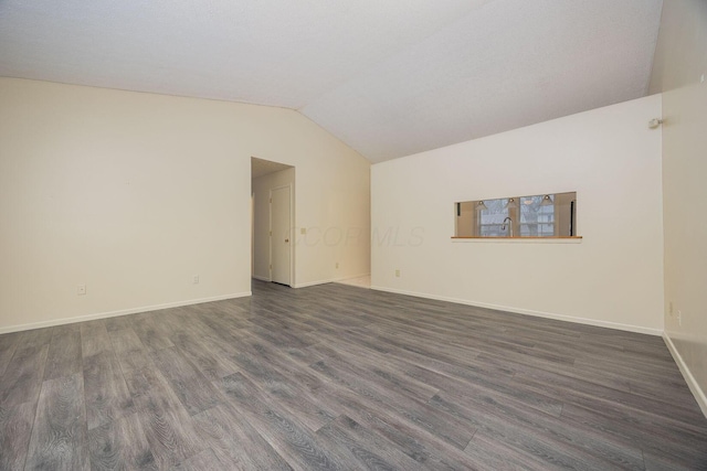 unfurnished room featuring lofted ceiling and dark hardwood / wood-style floors