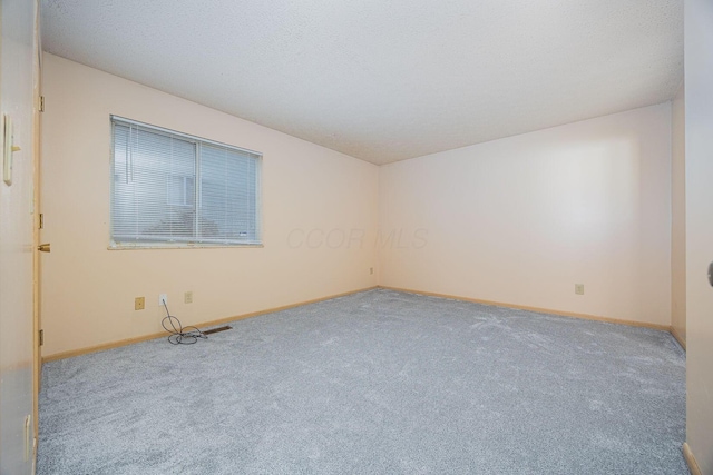 carpeted empty room featuring a textured ceiling