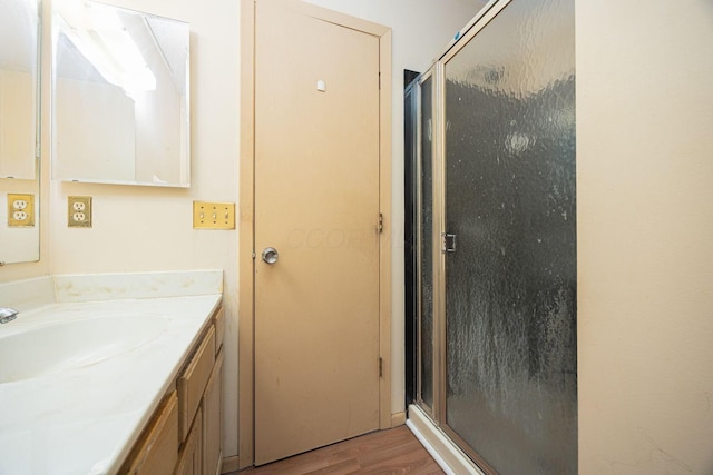 bathroom featuring hardwood / wood-style flooring, vanity, and an enclosed shower