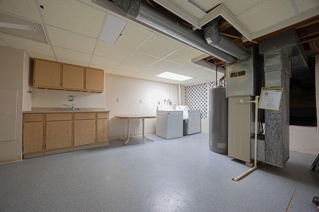 basement featuring water heater, washer and dryer, sink, and a drop ceiling