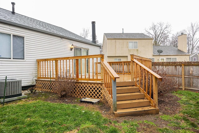 back of property with central AC unit and a deck