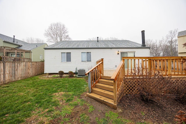 rear view of house with a wooden deck, a yard, and cooling unit