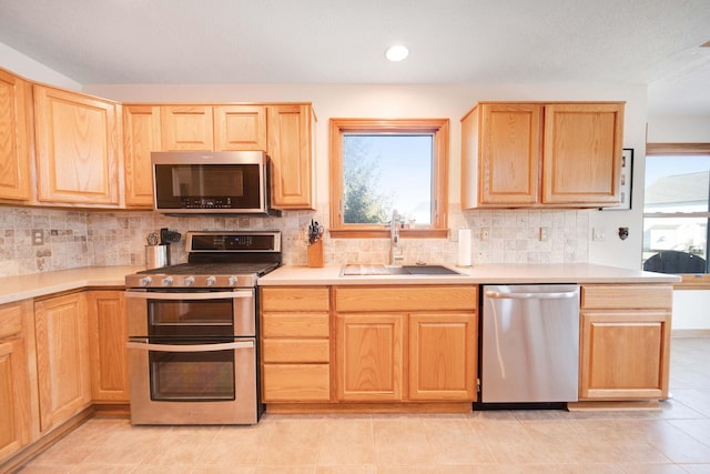 kitchen featuring tasteful backsplash, sink, stainless steel appliances, and light brown cabinets