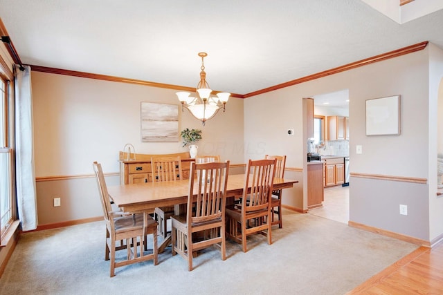 carpeted dining room with crown molding and a notable chandelier