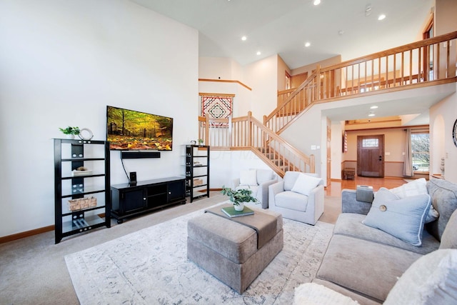 carpeted living room with a towering ceiling