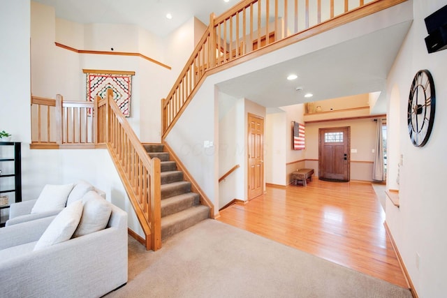 staircase featuring a towering ceiling and wood-type flooring