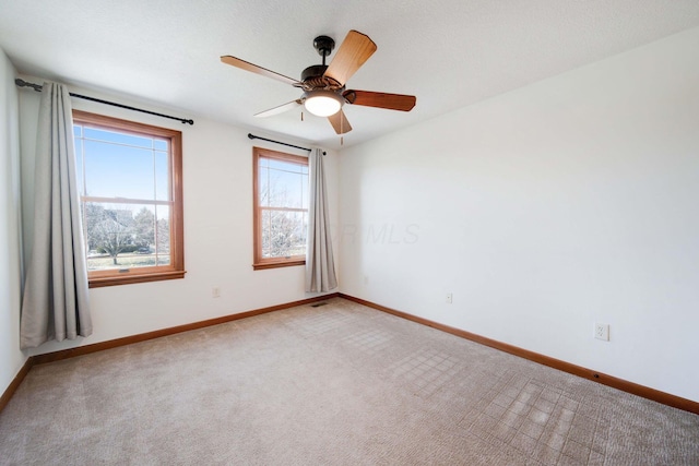 spare room featuring light carpet and ceiling fan