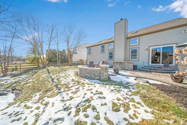 snow covered property with a patio and a fire pit