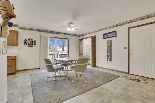 dining space featuring a textured ceiling, a ceiling fan, and baseboards