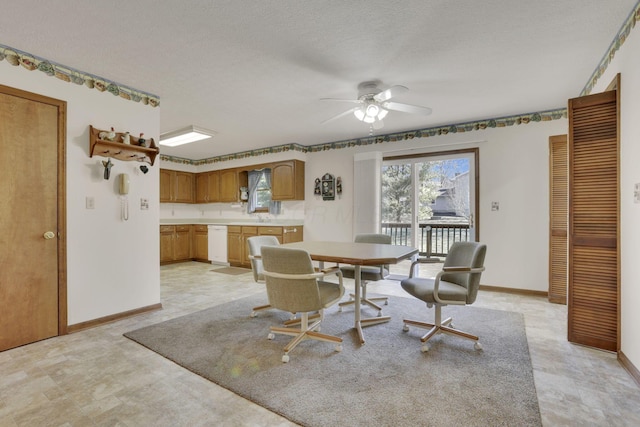 dining space with a textured ceiling, baseboards, and a ceiling fan