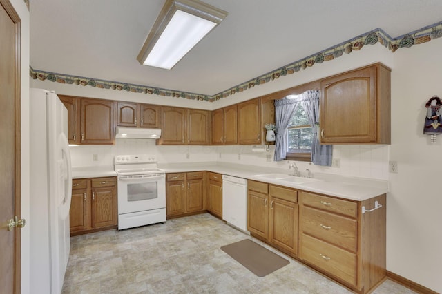 kitchen with white appliances, a sink, light countertops, under cabinet range hood, and backsplash