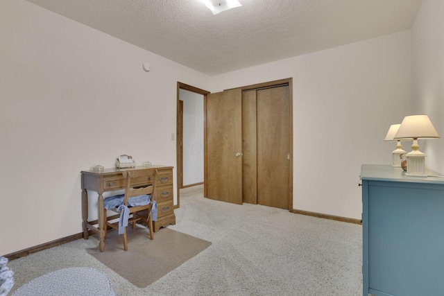 office area featuring baseboards, carpet floors, and a textured ceiling