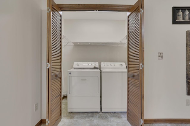 washroom with baseboards, laundry area, and washer and clothes dryer