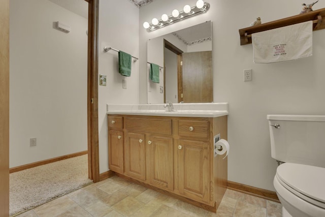 bathroom featuring vanity, toilet, and baseboards