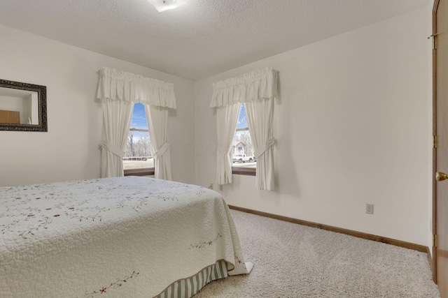 unfurnished bedroom featuring baseboards, carpet floors, and a textured ceiling