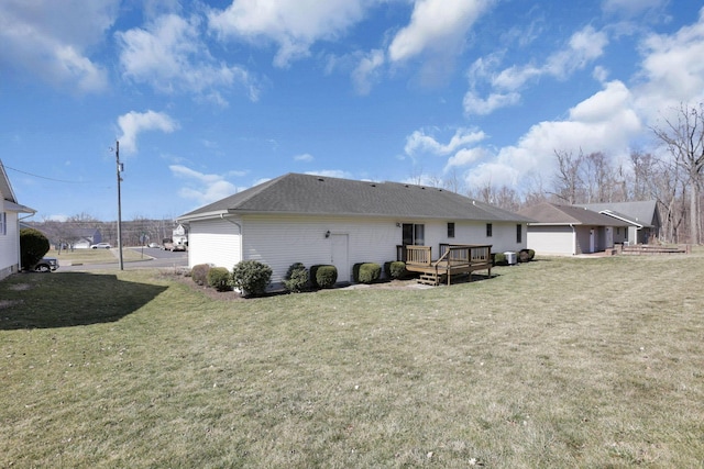 rear view of property featuring a wooden deck and a yard