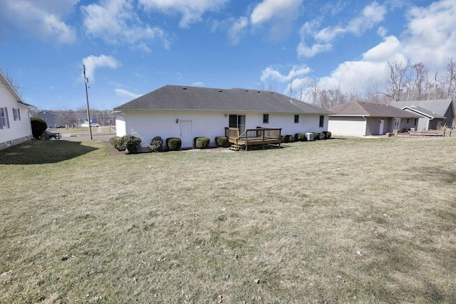 back of house featuring a deck and a lawn