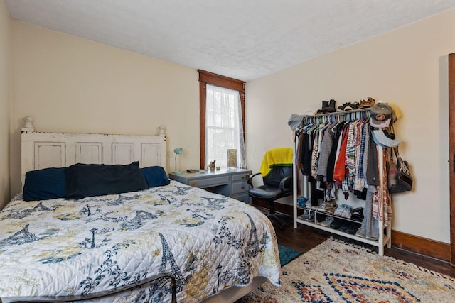 bedroom featuring dark hardwood / wood-style flooring and a textured ceiling