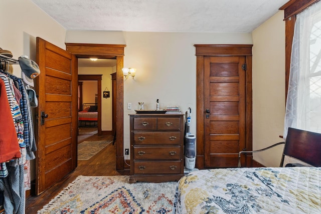 bedroom with dark hardwood / wood-style flooring and a textured ceiling