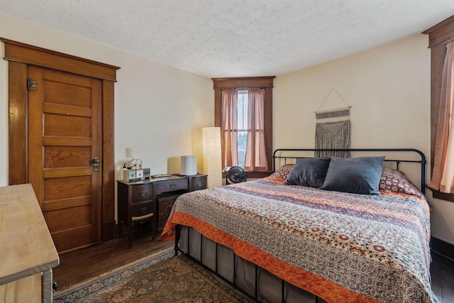 bedroom with dark wood-type flooring and a textured ceiling