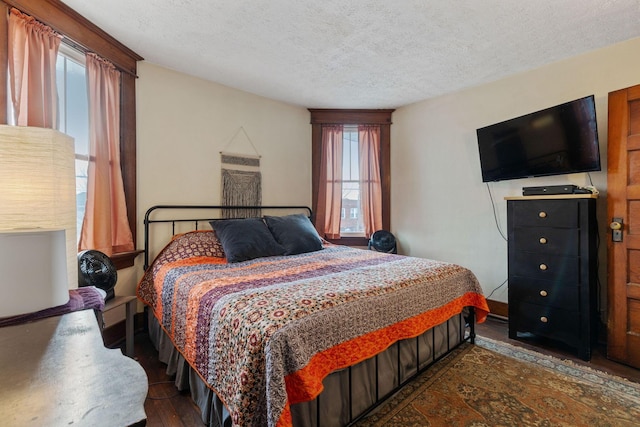 bedroom featuring dark hardwood / wood-style floors and a textured ceiling