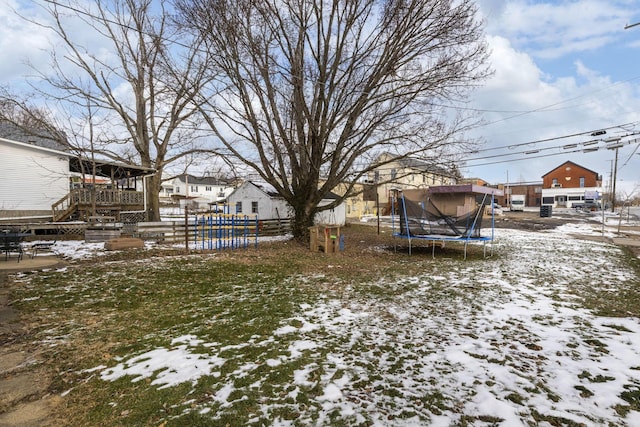 yard covered in snow featuring a trampoline