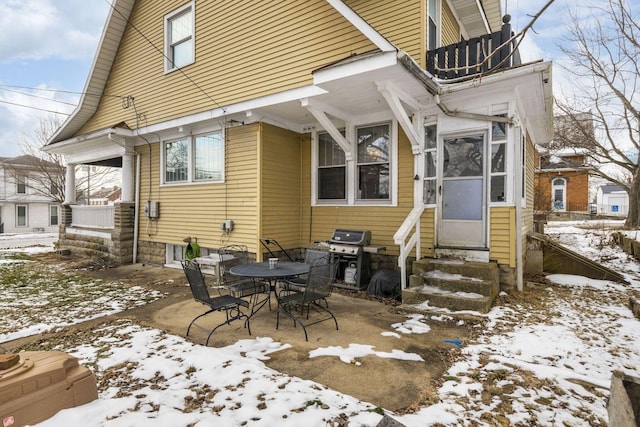 view of snow covered back of property