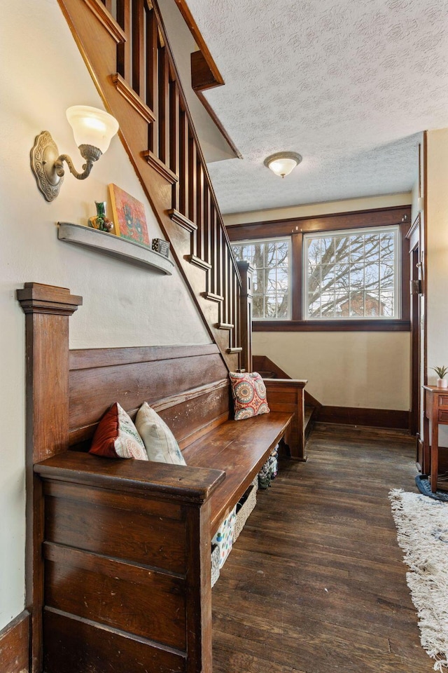 staircase featuring wood-type flooring and a textured ceiling