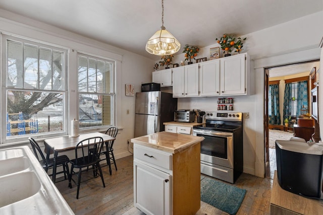 kitchen with hardwood / wood-style flooring, white cabinetry, stainless steel appliances, a healthy amount of sunlight, and decorative light fixtures