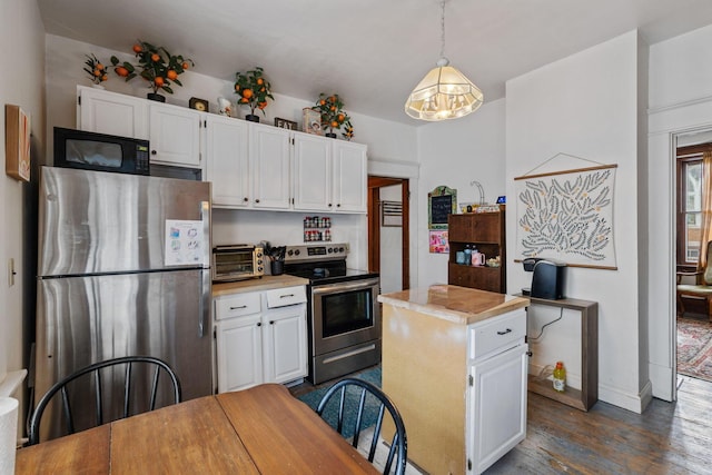 kitchen with a kitchen island, pendant lighting, white cabinets, dark hardwood / wood-style flooring, and stainless steel appliances