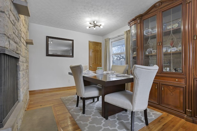 dining room with hardwood / wood-style floors, a chandelier, and a textured ceiling