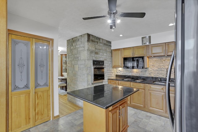 kitchen with a kitchen island, a stone fireplace, decorative backsplash, ceiling fan, and black appliances