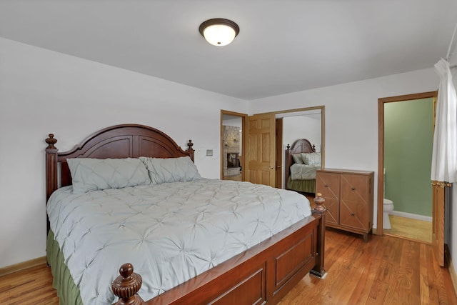 bedroom with connected bathroom and light hardwood / wood-style flooring