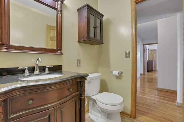 bathroom with vanity, hardwood / wood-style flooring, and toilet