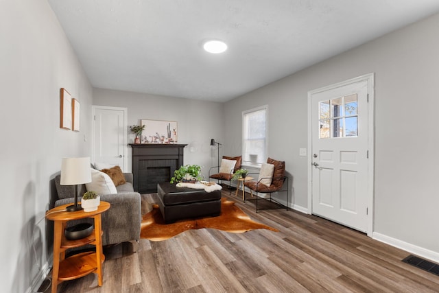 living room with hardwood / wood-style flooring and a brick fireplace