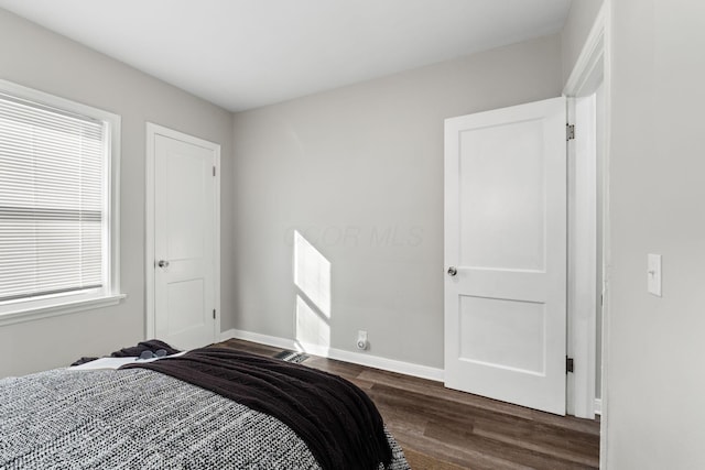 bedroom with dark hardwood / wood-style flooring