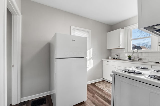 kitchen with sink, white appliances, dark wood-type flooring, backsplash, and white cabinets