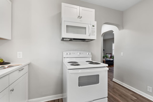 kitchen with dark hardwood / wood-style floors, white cabinets, and white appliances