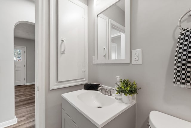 bathroom featuring hardwood / wood-style flooring, vanity, and toilet