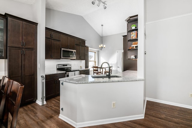 kitchen featuring pendant lighting, sink, lofted ceiling, stainless steel appliances, and light stone counters