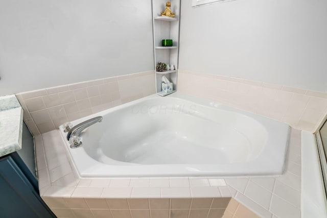 bathroom featuring vanity and tiled bath