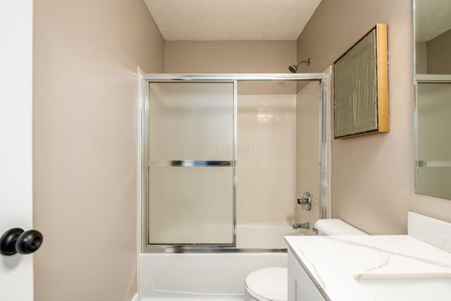 full bathroom with enclosed tub / shower combo, vanity, toilet, and a textured ceiling