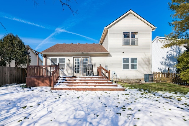 snow covered house featuring a deck, central air condition unit, and french doors