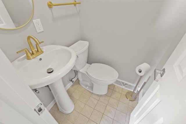 bathroom with toilet and tile patterned flooring