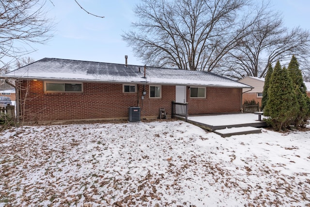 snow covered house with central AC unit