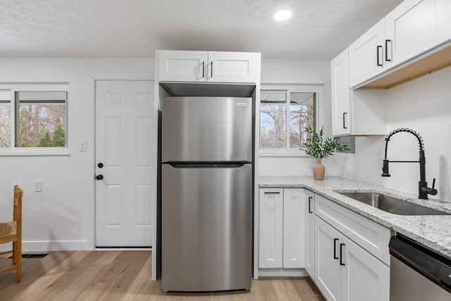 kitchen with appliances with stainless steel finishes, sink, and white cabinets